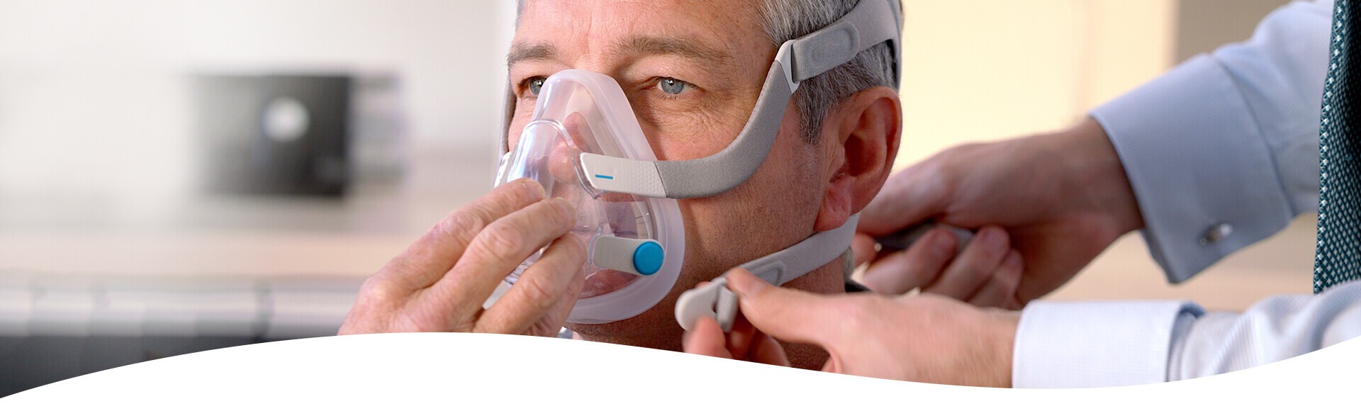Arzt passt Schlafapnoe-Patienten die CPAP-Maske an.