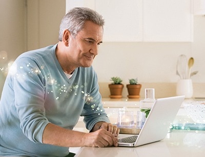 Mann vereinbart Online Termin an Laptop