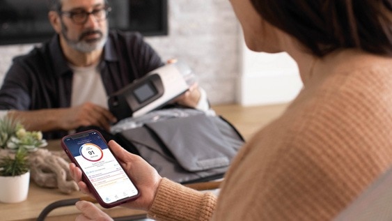 Frau mit myAir-App, Mann packt CPAP-Gerät aus
